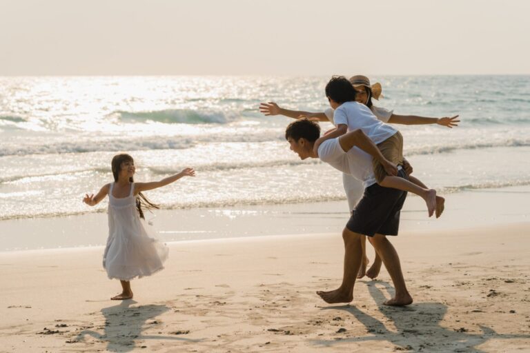 Asian young happy family enjoy vacation beach evening dad mom kid relax playing together near sea when sunset while travel holiday lifestyle travel holiday vacation summer concept scaled