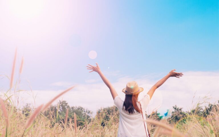 Woman traveler with camera holding hat breathing field grasses forest wanderlust travel concept space text atmosperic epic moment scaled